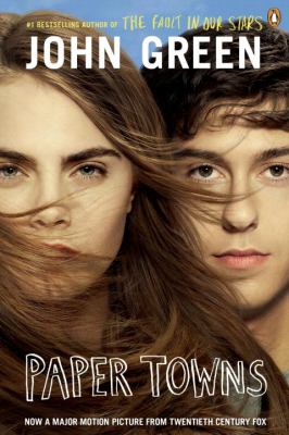 Book cover of Paper Towns by John Green The cover shows a close up of two faces side by side partially covered by windblown hair A young woman with long brown hair and strong eyebrows is on the left while a young man with short brown hair and light skin is on the right The title Paper Towns appears in bold white letters at the bottom with the authors name John Green in large white letters at the top