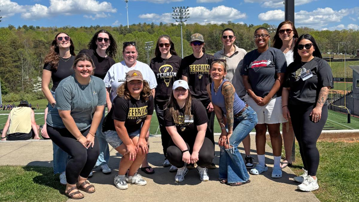 A group of women wearing Ferrum College alumni shirts pose togeether outside