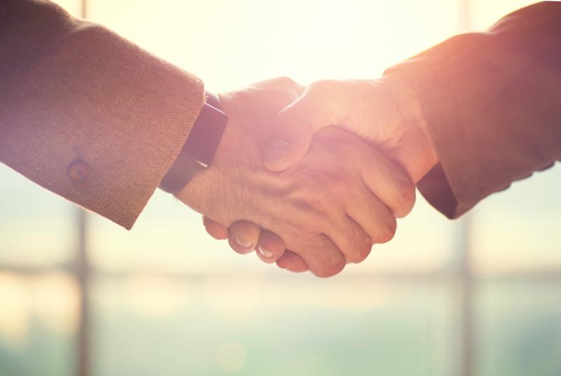 Business handshake. Business handshake and business people concept. Two men shaking hands over sunny office background. Partnership_ Deal