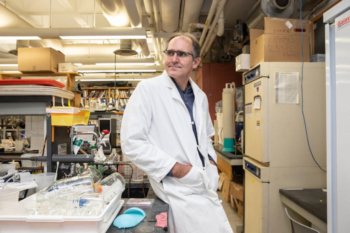 John Dennehy in his lab wearing white lab coat
