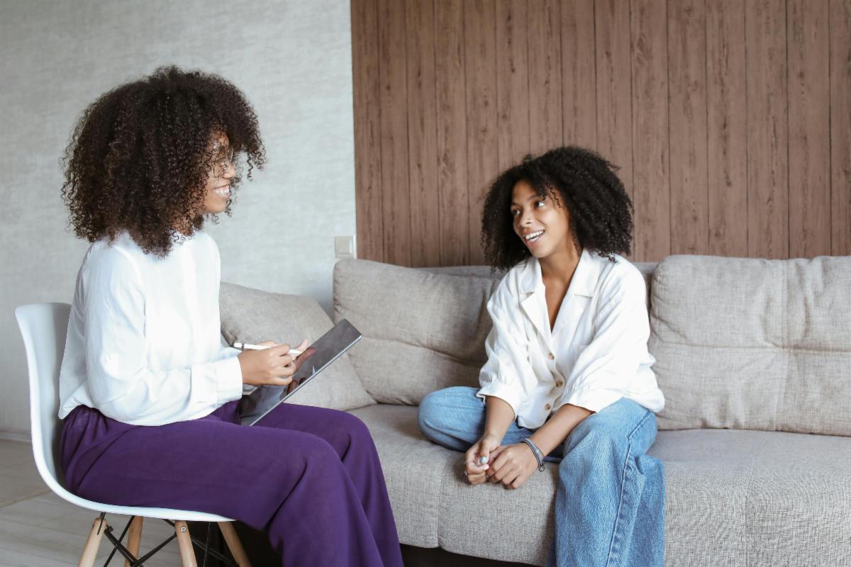 two women talking in office on couch and chair