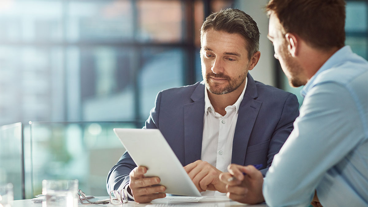 Photoof two men looking at a tablet