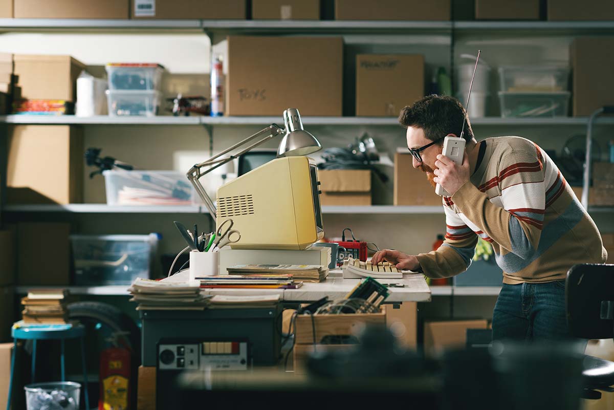 Man at his computer talking on the telephone