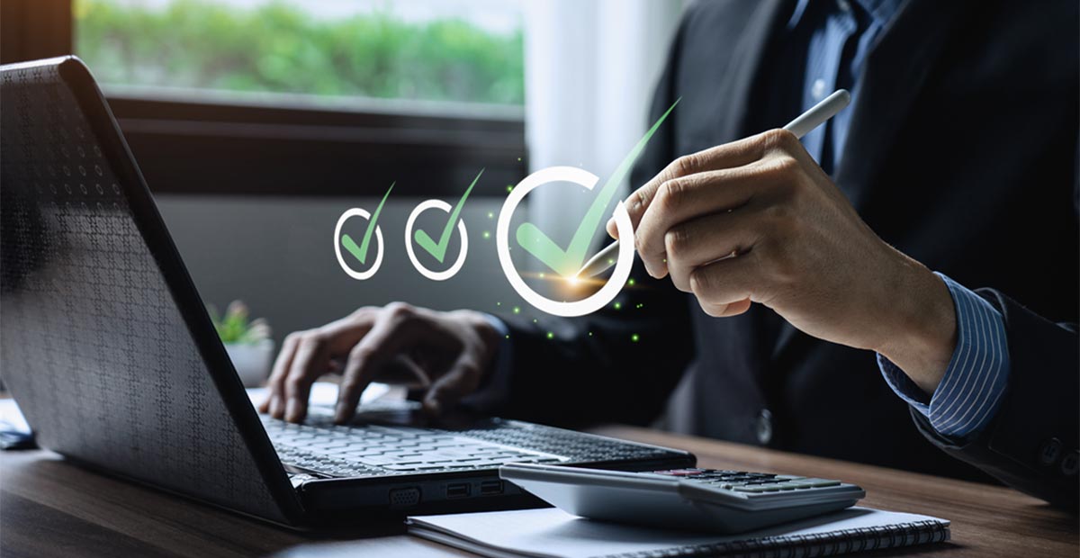 A man checking off tasts on his laptop computer