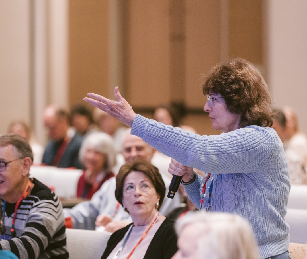 Patient in Ask the Doctors panel holding a mic with a raised hand asking a question