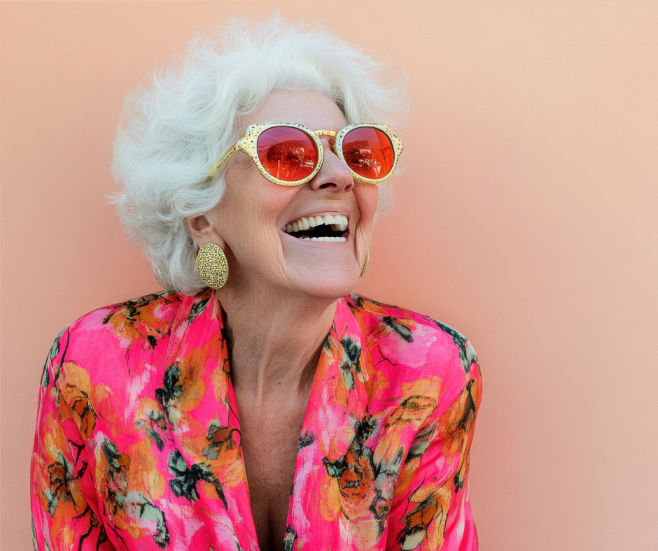 Photo of woman laughing wearing rose-colored sunglasses and bright clothing