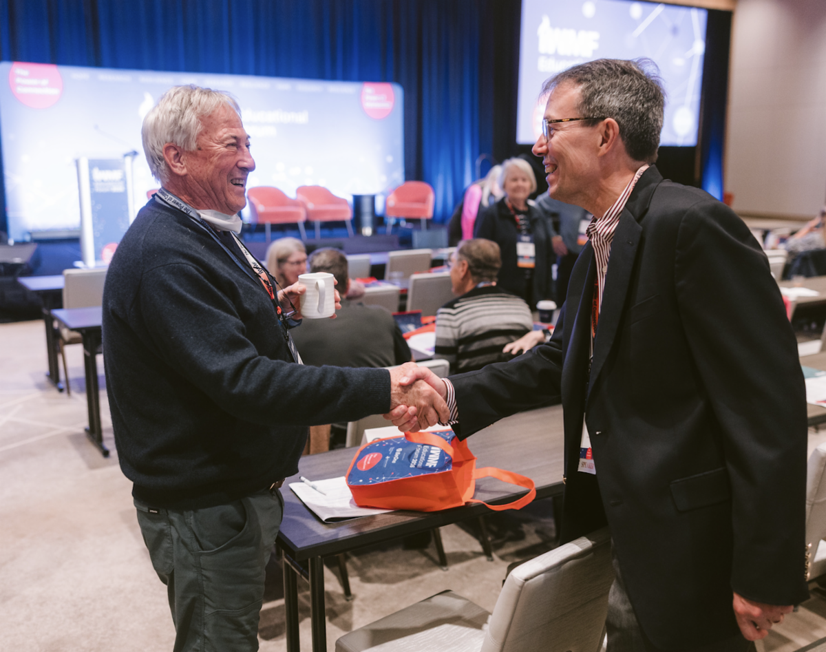 Dr. Jeff Matous shakes hands with a satisfied WM community member