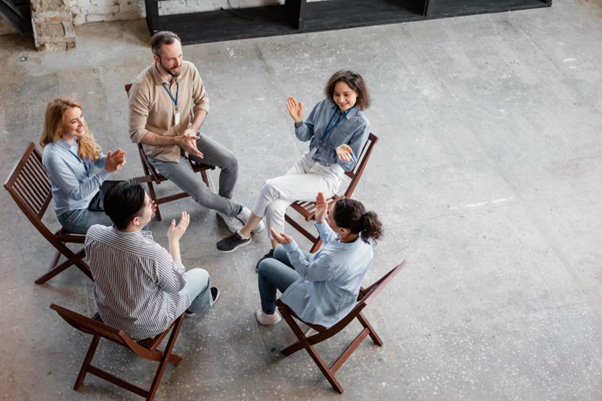 A group of people seated in a circle having a discussion.