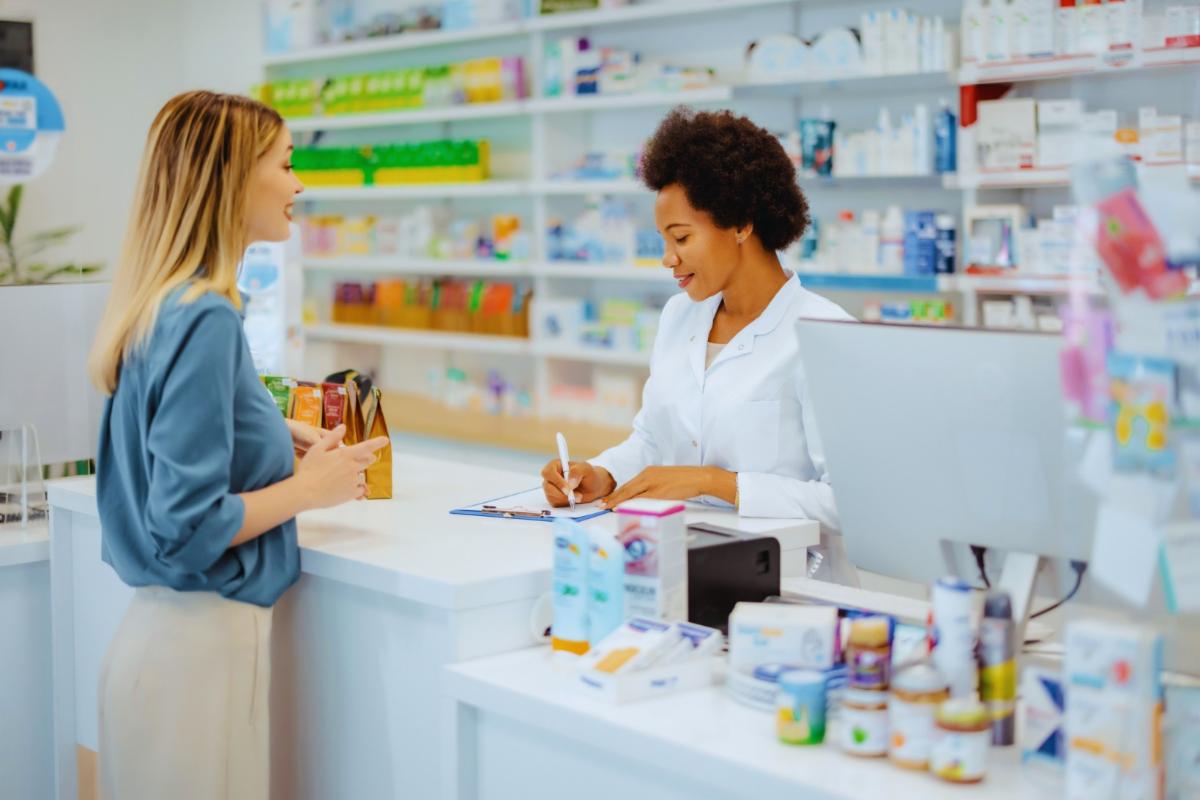 woman paying the pharmacist at the pharmacy counter