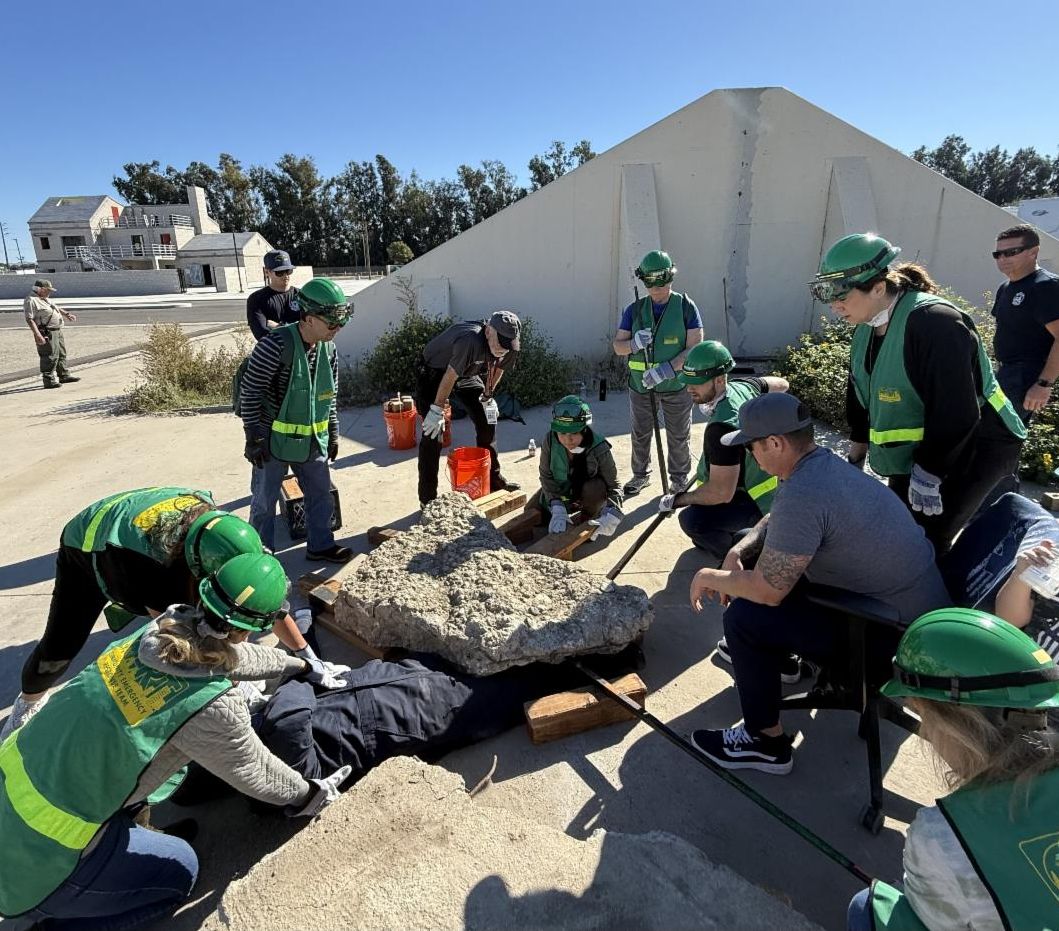 Community Emergency Response Team training completing a drill helping fake earthquake victims get out of concrete rubble