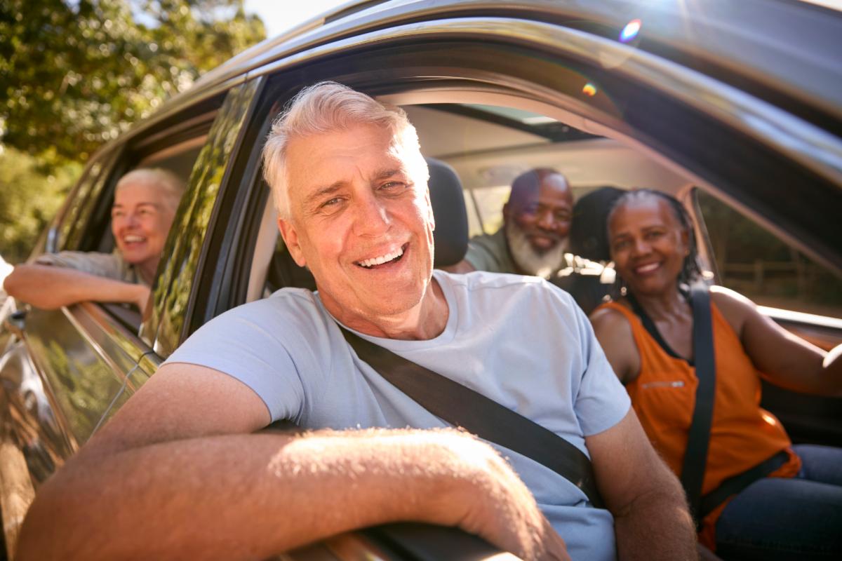 Four smiling seniors taking a car ride