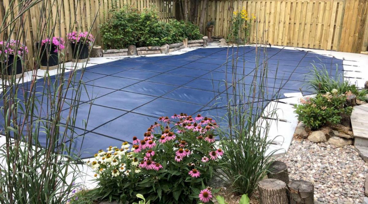 Pool cover placed directly over someone's pool in their backyard.