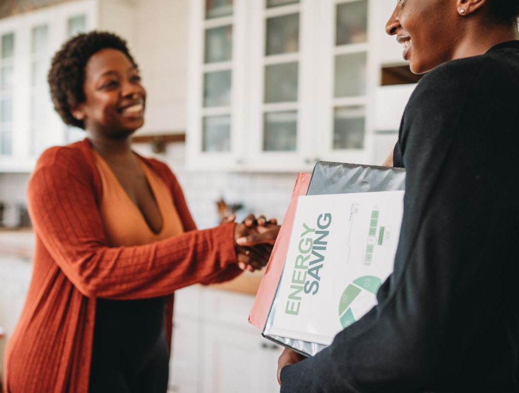 homeowner shaking hands with a home energy installation representative