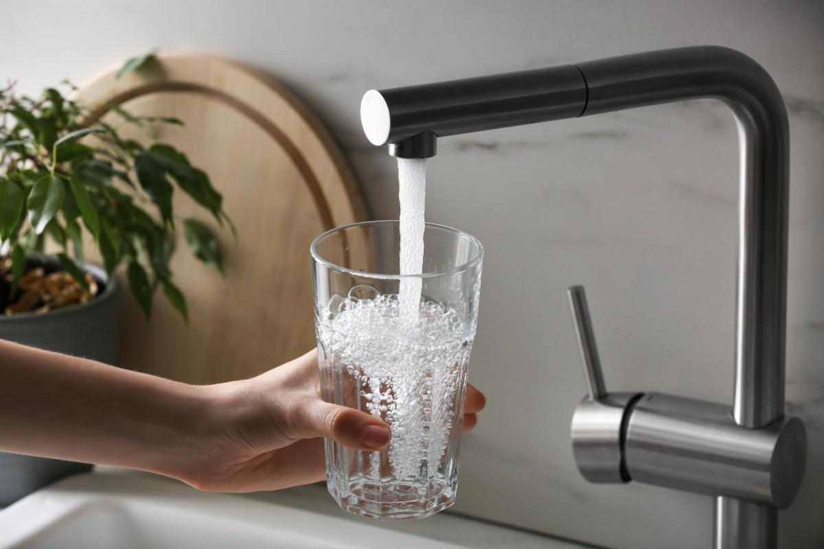glass being filled with a kitchen faucet