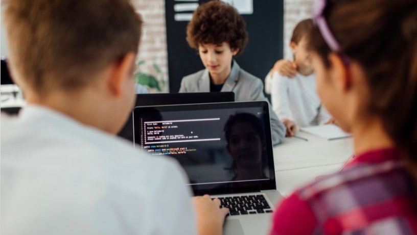 four students doing coding on computers