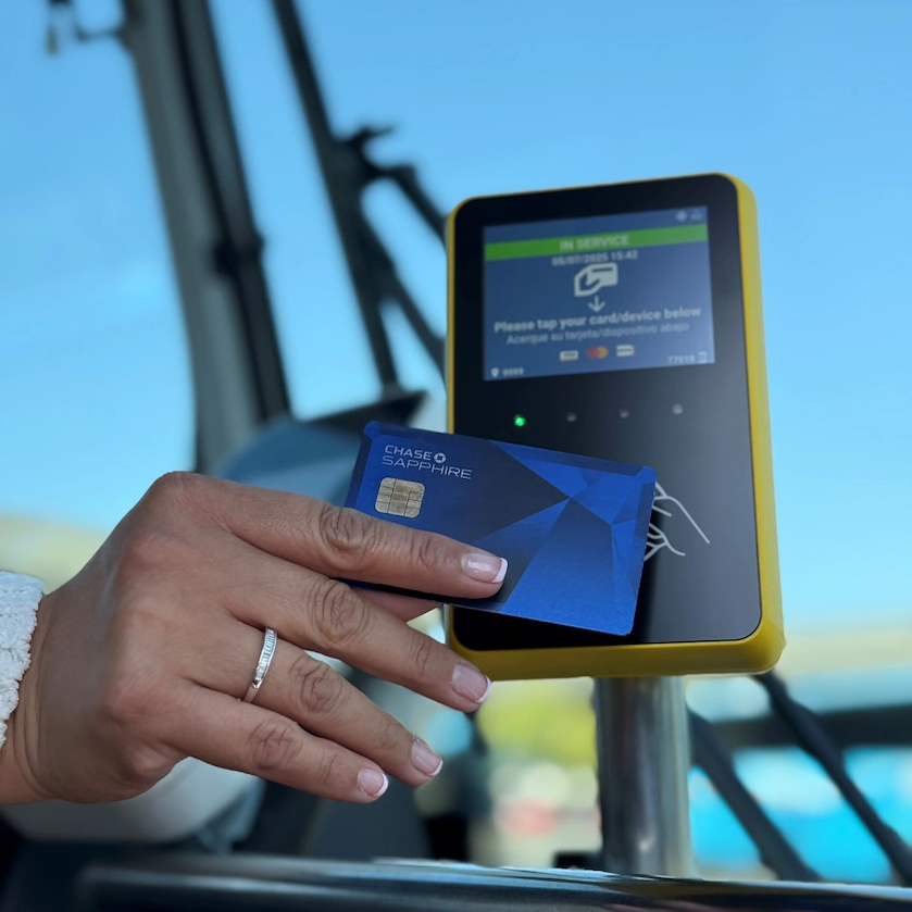 A hand tapping a credit card on the new Tap2Pay system.