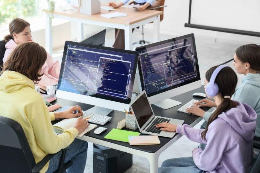 Students coding on desktop computers.