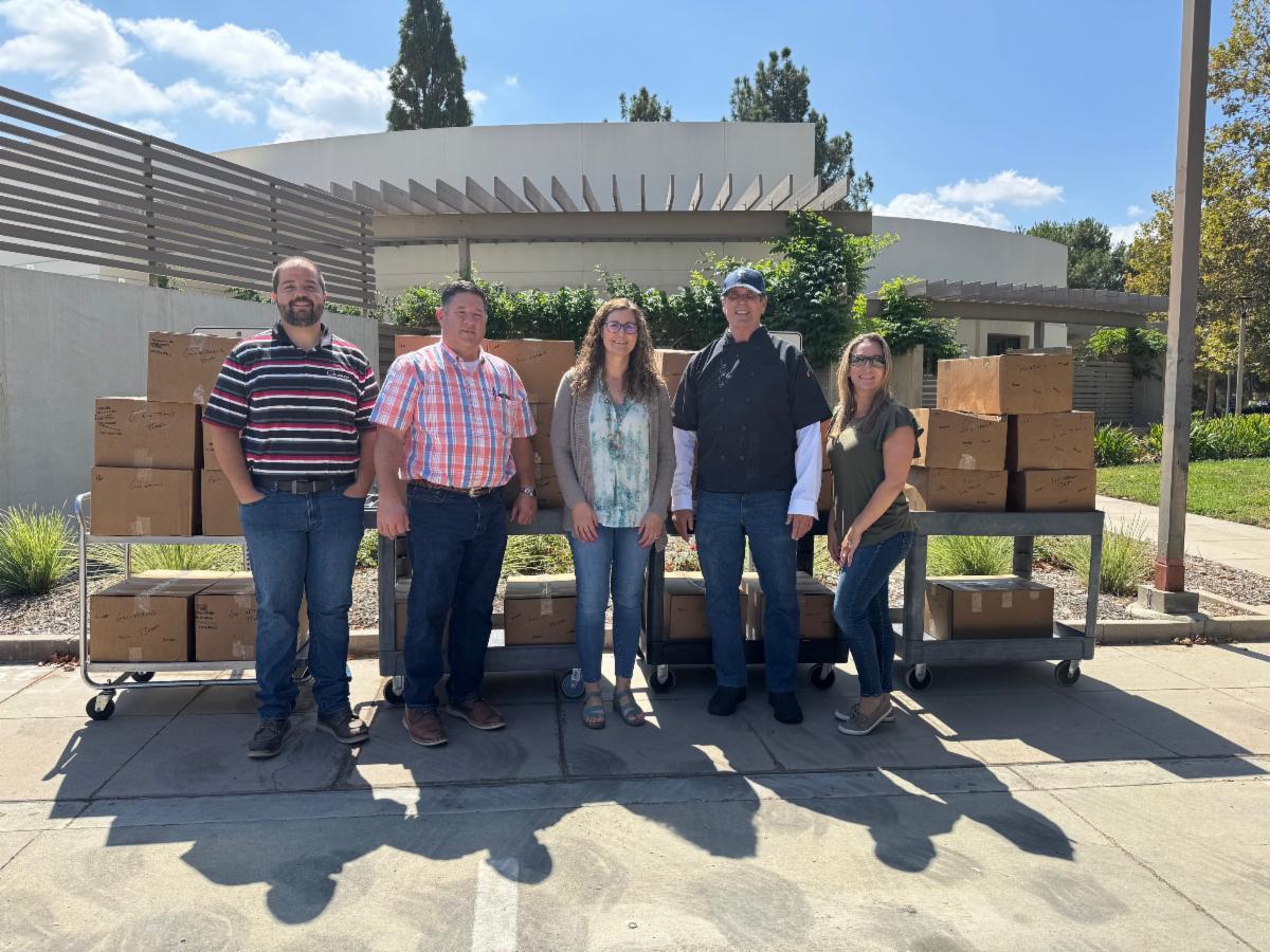 Representatives from PW Gillibrand and the Simi Valley Senior Center stand outside the center with boxes of donated beef