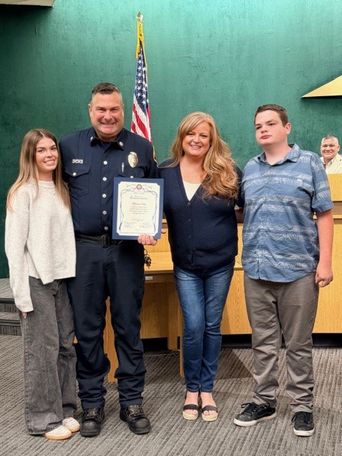 Fire Captain Malcolm Dicks and family pose for photo at City Council in honor of life-saving Commendation for actions during Palisades Fire