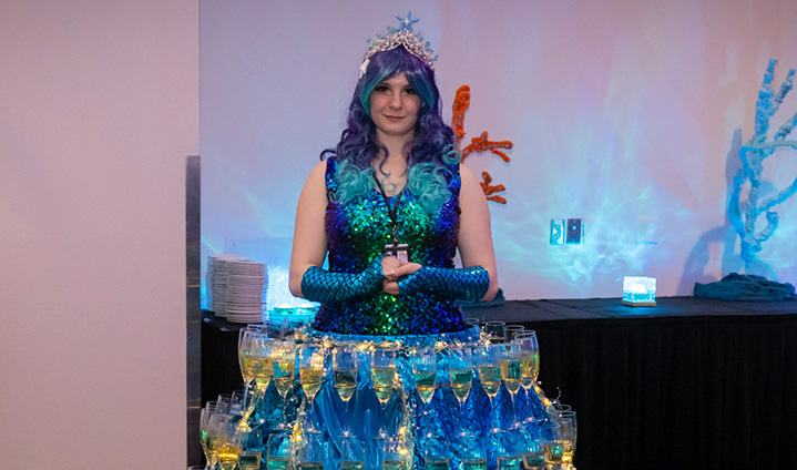 Gala princess in hoop dress containing glasses of champagne