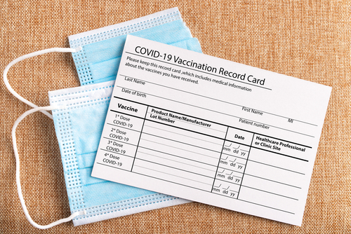 Coronavirus vaccination record card. Protective mask divided into two parts. Concept of defeating Covid-19