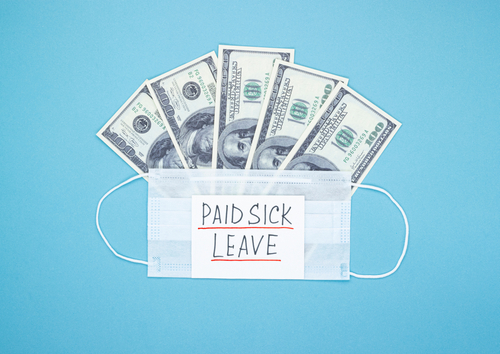 Medical mask with dollars and the words paid sick leave on a blue background. Concept of economic dependence on the COVID-19 coronavirus pandemic