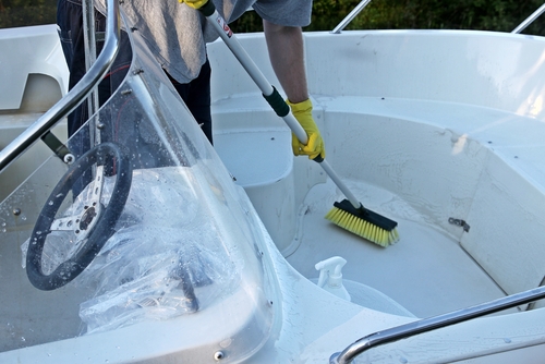 Cleaning boat with brush by hands