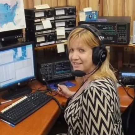 Ham radio operator wearing headsets in front of radio equipment
