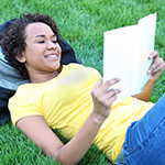 Jovencita adolescente felizmente leyendo un libro