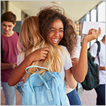 High school students happily hugging each other_ with acceptance letters in their hands