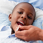 Un ni_o peque_o al que le est_n tomando la temperatura.