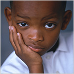 Young boy with his chin in his hand_ sporting a dubious look on his face