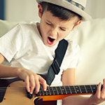 Ni_ito cantando y tocando la guitarra.