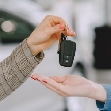Hand giving over car keys to purchaser.