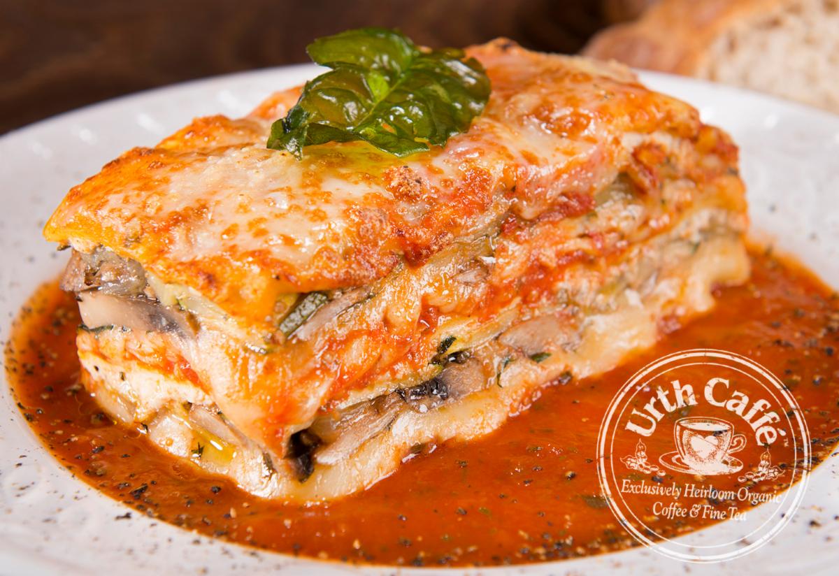 Photo of Urth Caffé Lasagna with basil garnish and Urth logo.
