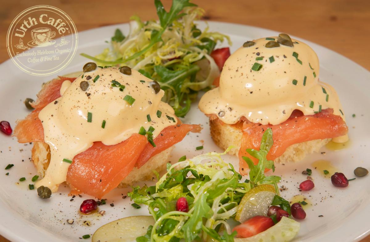 Photo of Urth Caffé Salmon Eggs Benedict Brioche with garnish and Urth logo.