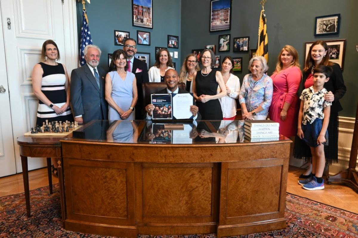 Photo of Governor Moore with Maryland Department of Aging staff members and legislators at the signing ceremony for Longevity Ready Maryland.