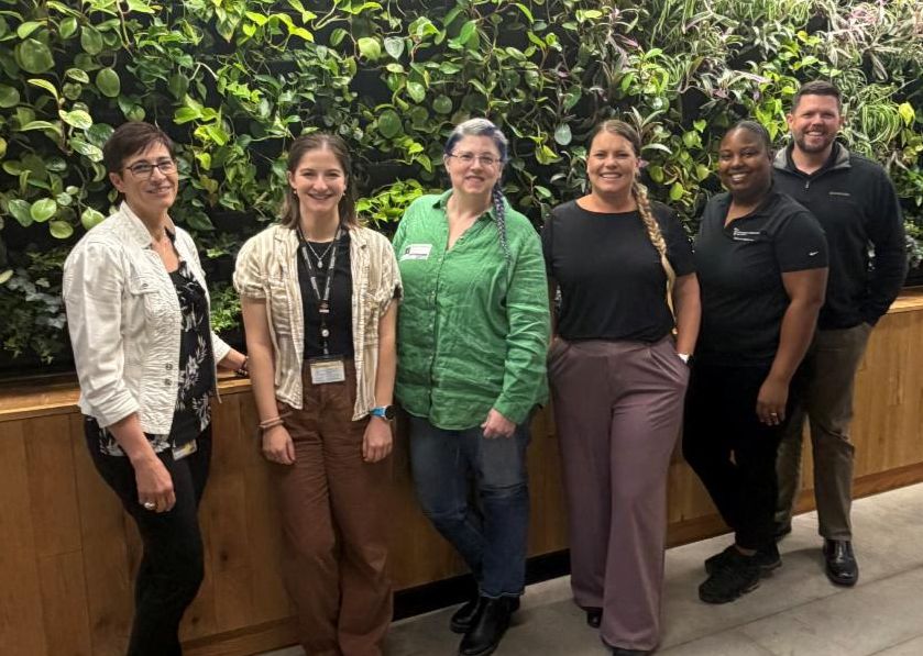 Group of people standing in front of green wall