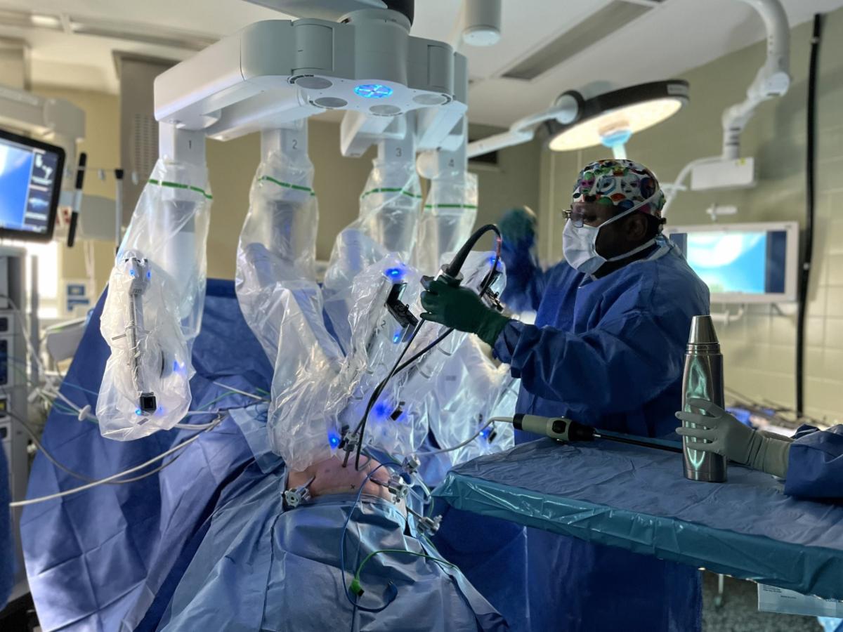 A doctor performs robotic surgery on a patient.