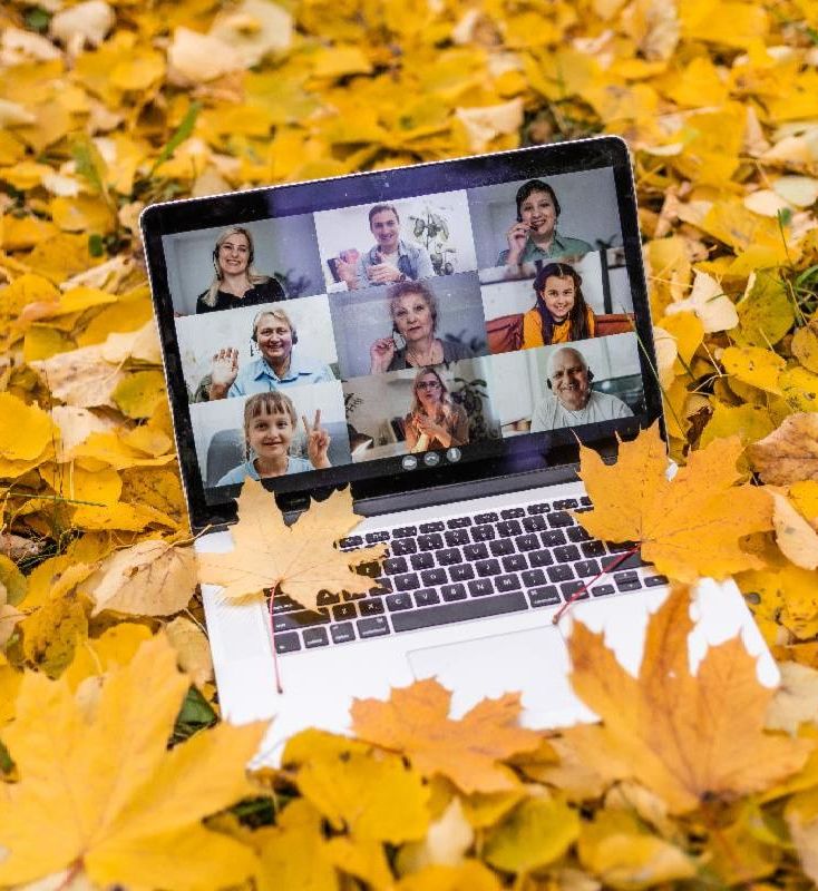 Laptop in yellow fallen leaves in the fall.