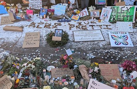A street display of signs and flowers as a memorial for Alex Pretti
