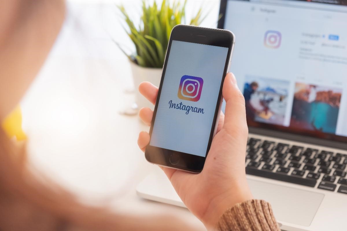 A hand holding a cellphone with the Instagram logo on the phone screen