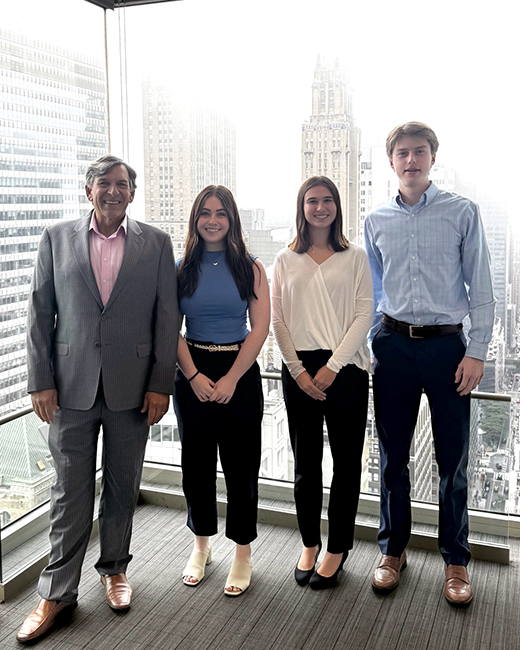 Varadero interns and Fernando Guerrero in front of a window in the NYC financial district