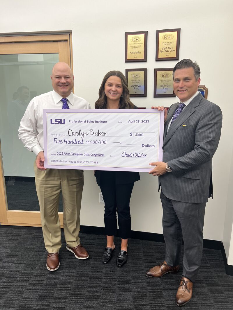 PSI student is presented with a large check $500 scholarship.