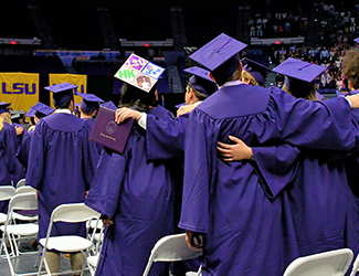 Undergraduates link arms and sign the alma mater.