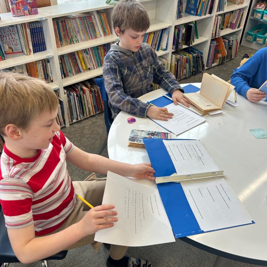 second graders lay in the snow