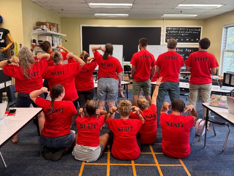staff show off their cool new t-shirts that say "Staff"