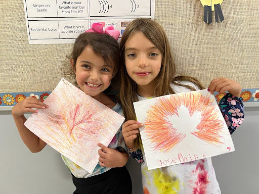 Two students show off their leaf art
