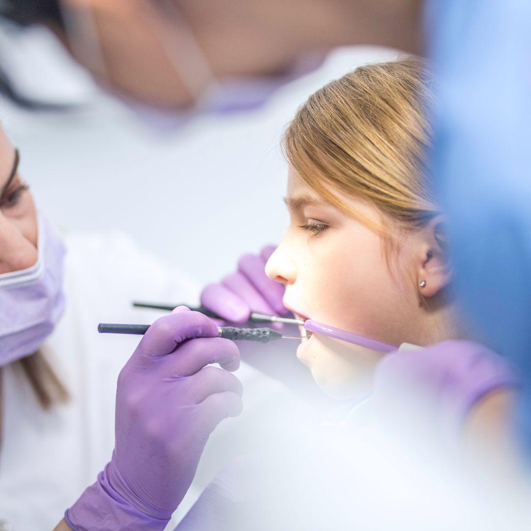 Dental Hygienist Looking at a young girls teeth