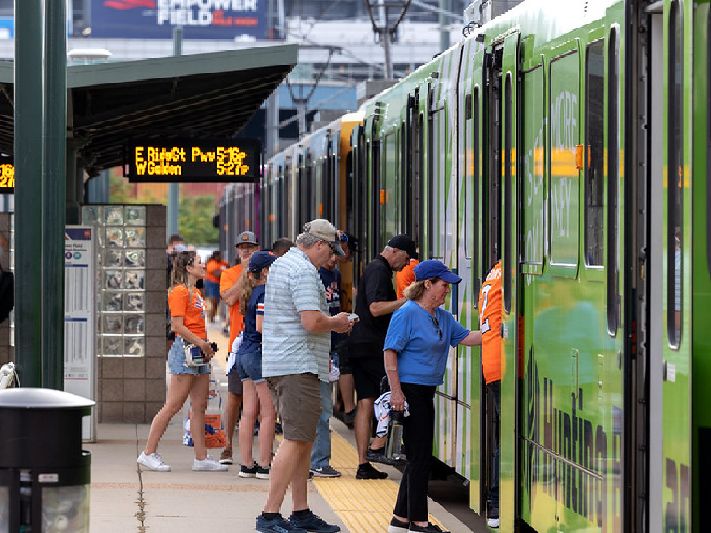 Broncos fans board light rail at Empower Field at Mile High Station